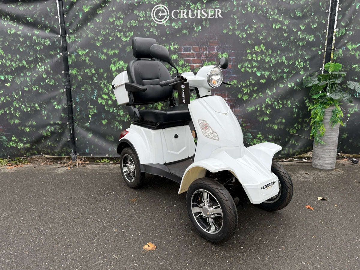 Rollz 4 wiel Ecruiser in wit, geparkeerd op asfalt voor groene achtergrond