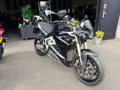 Zwarte Energica EVA R elektrische motorfiets geparkeerd bij showroomingang